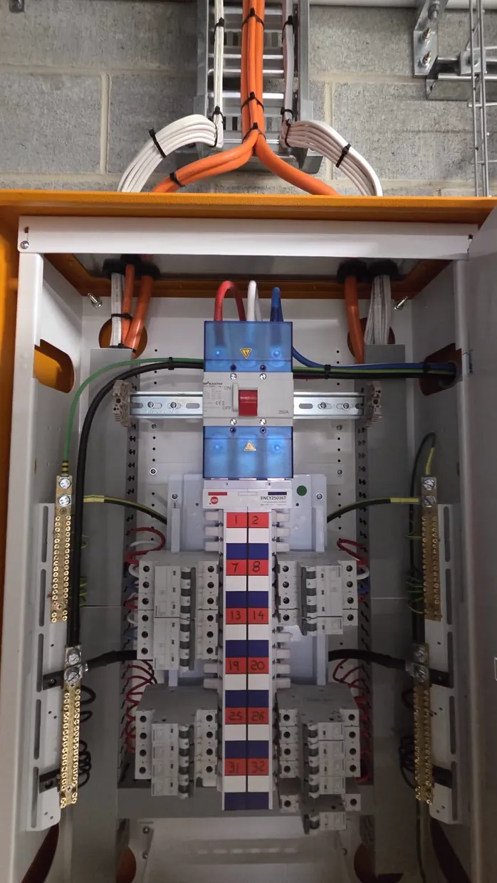 Distribution board mid-installation with numbered circuits and RCBOs on both sides of the chart